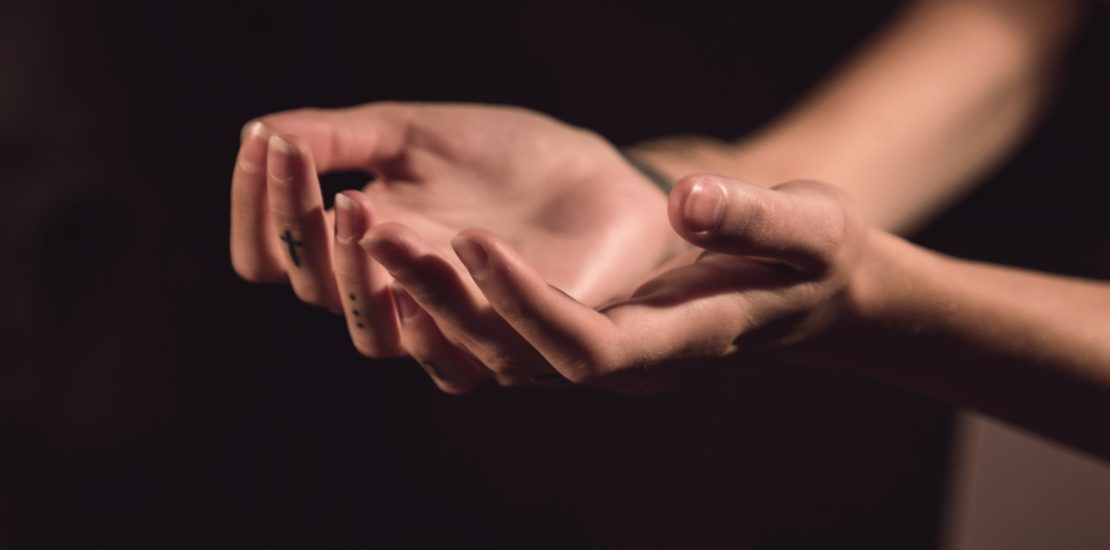 A woman is holding something in her hands in a dark room.