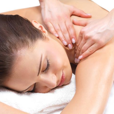 A woman is laying on a towel getting a massage.