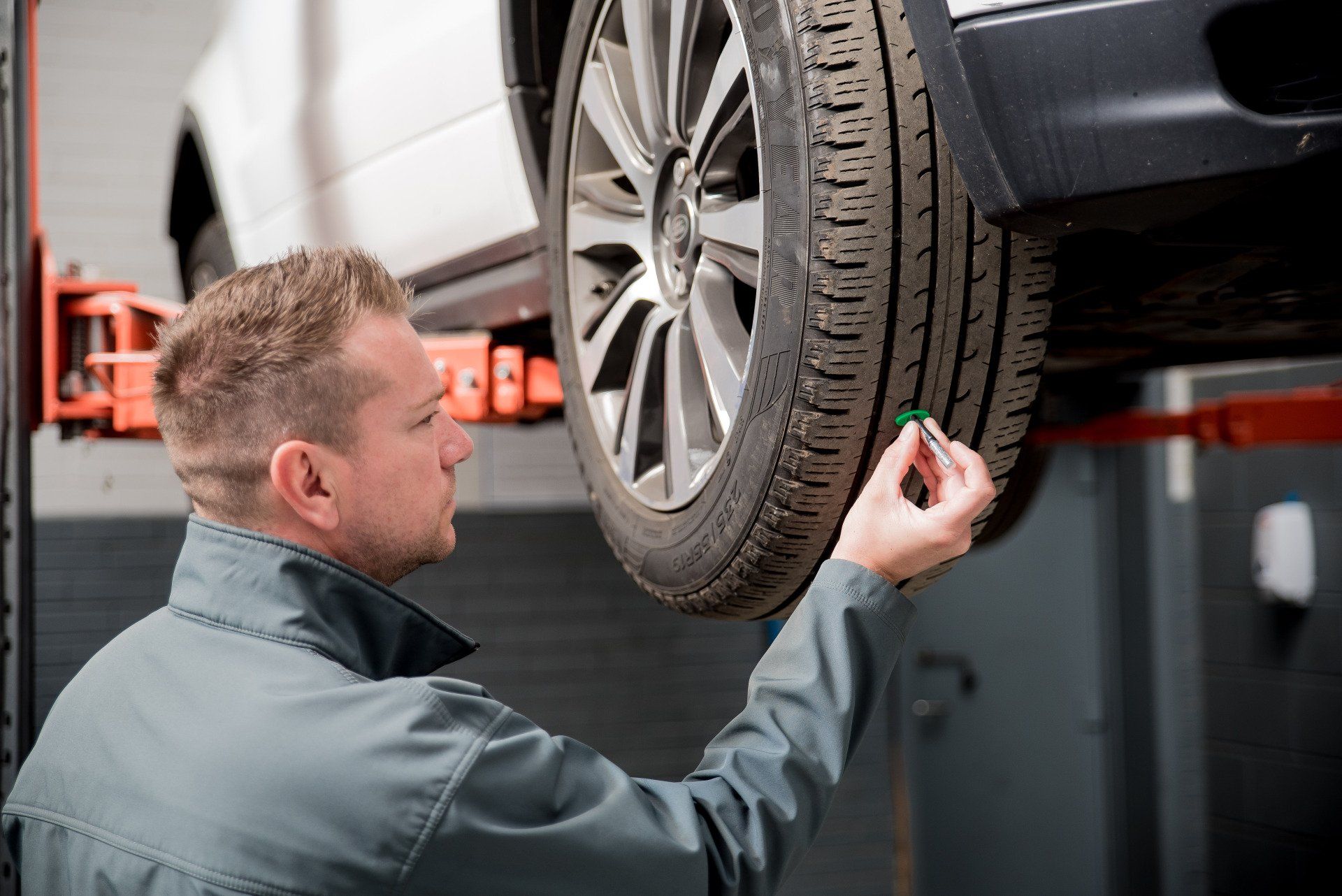 Technician checking the tread on a tyre.