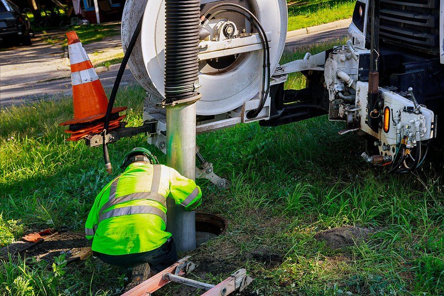 worker doing septic tank pumping