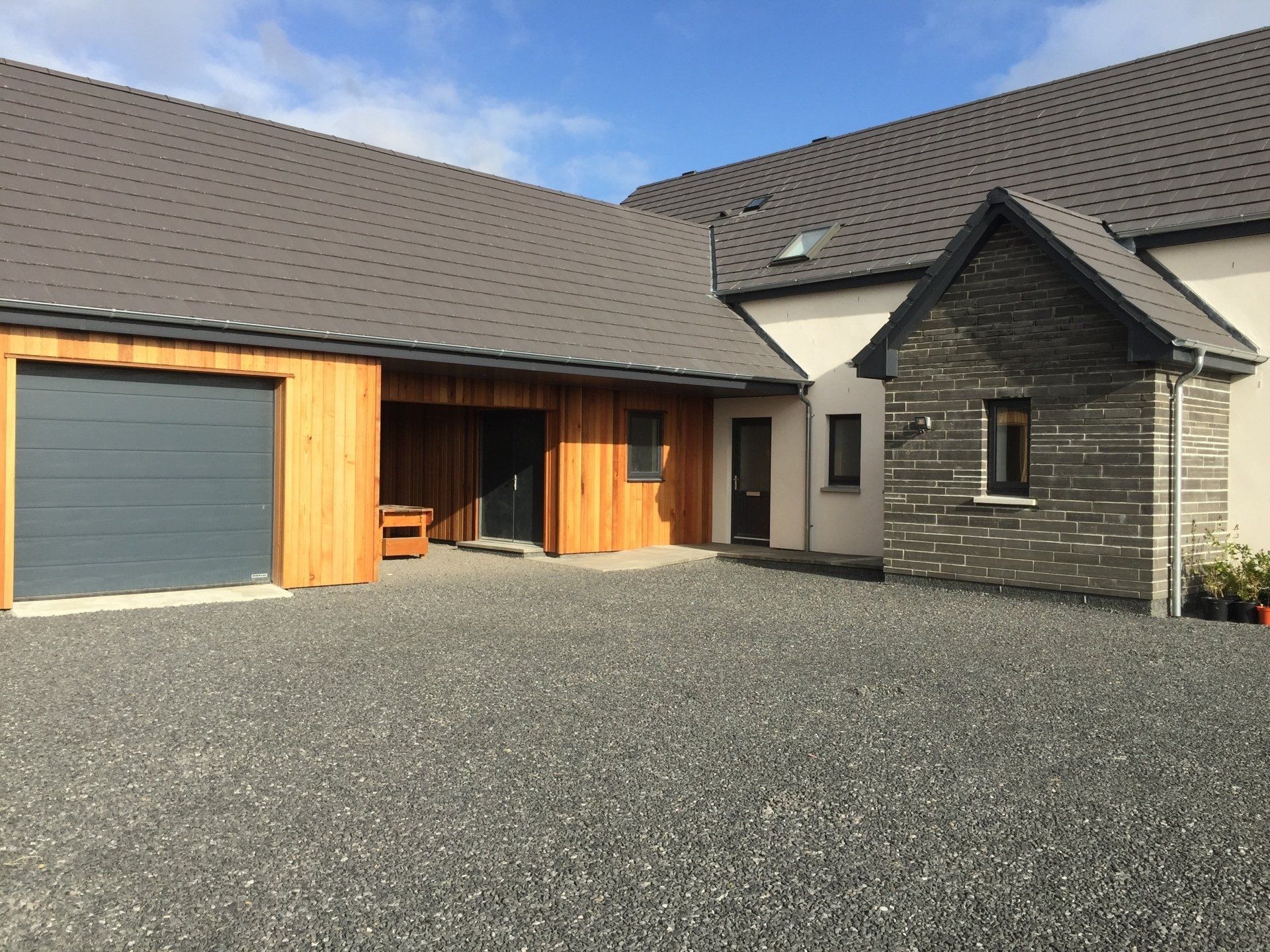 Bespoke mixture of flamed Caithness stone, wood and K-Rend roughcasting