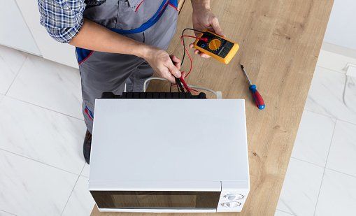 Technician Repairing Oven — Kitty Hawk, NC — Coastland Appliance LLC Technician Repairing Oven — Kitty Hawk, NC — Coastland Appliance LLC