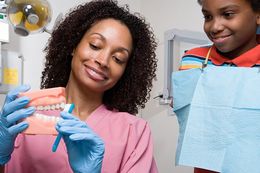 Dentist talking to male patient and presenting results on Dental x-ray film About the problem of the patient in dental office