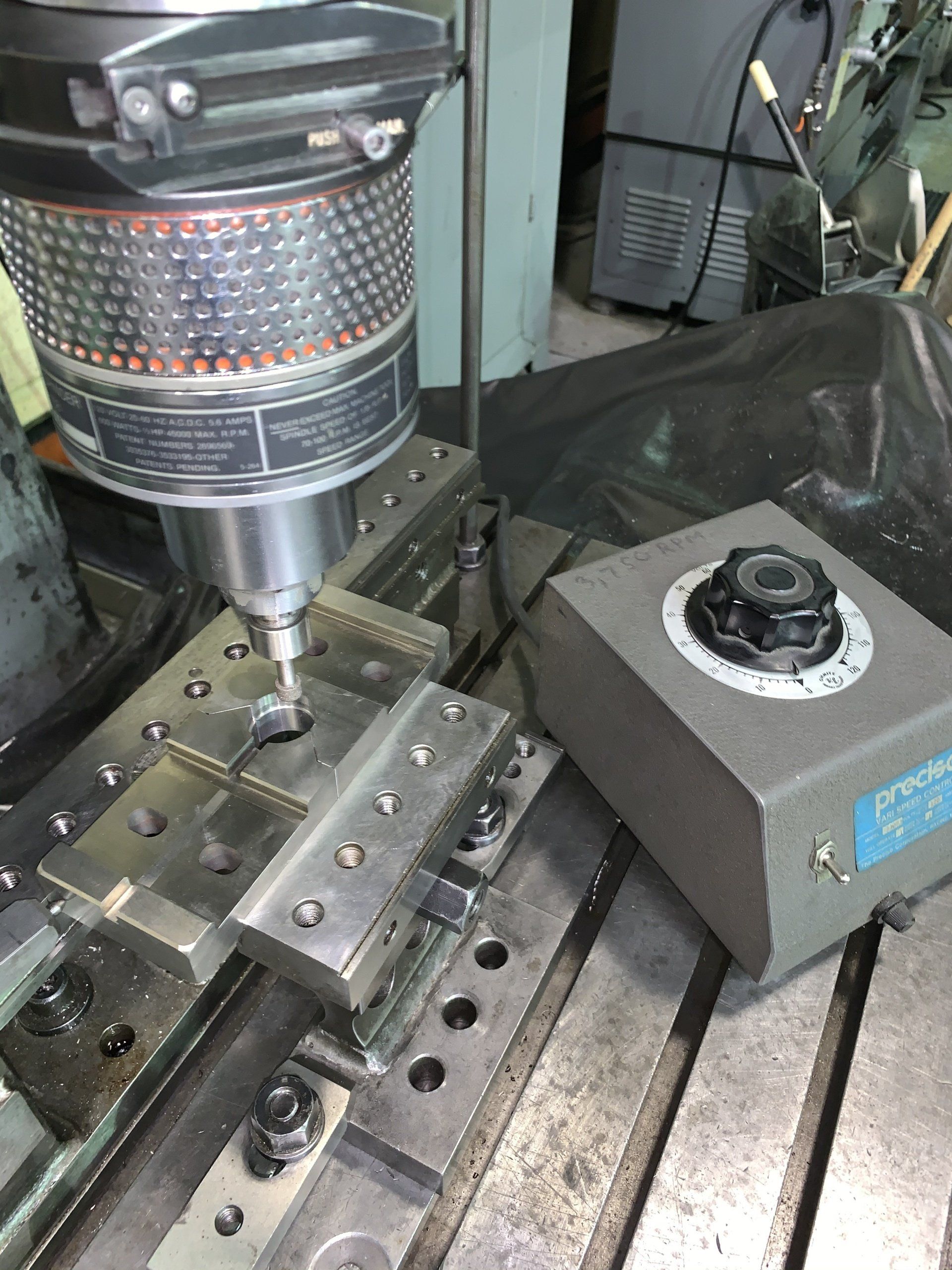A machine is being used to make a hole in a piece of metal