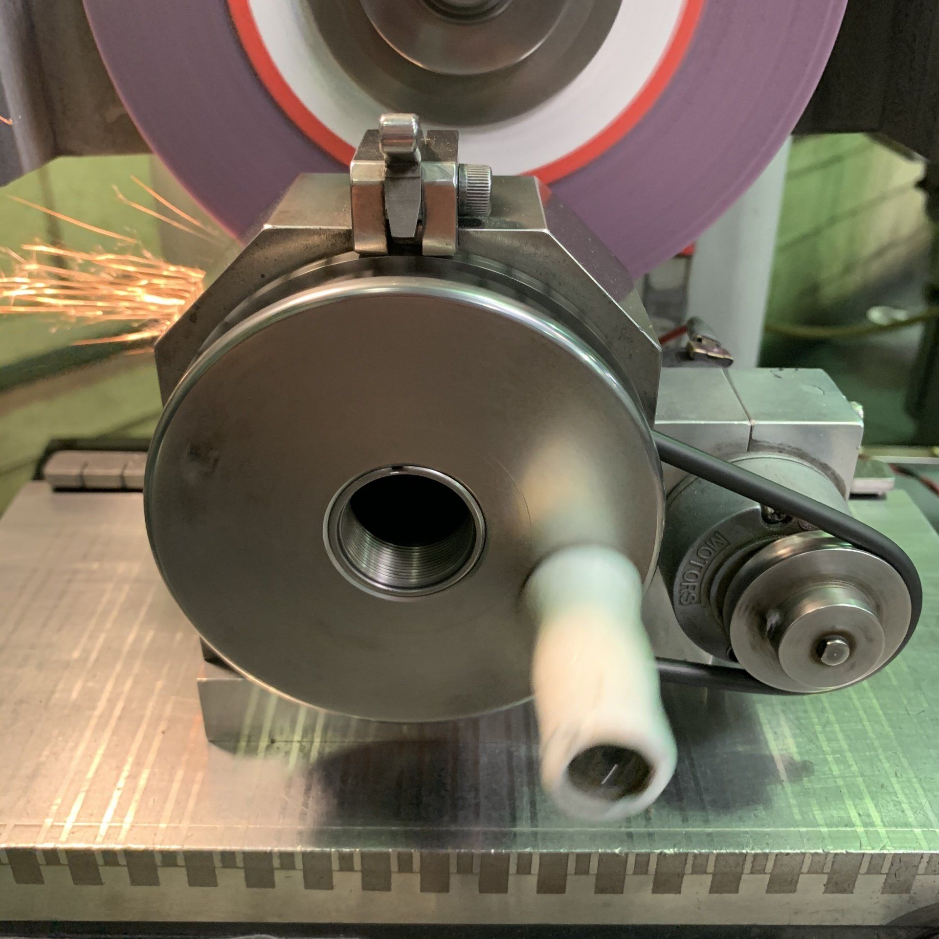 A machine with a purple grinding wheel in the background