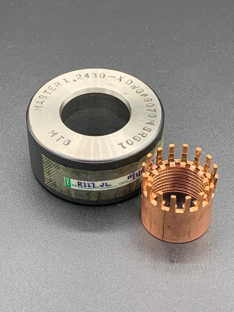 A metal ring and a copper nut are sitting next to each other on a table.