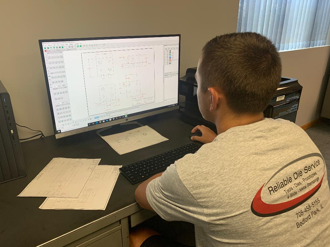 A man is sitting at a desk using a computer.