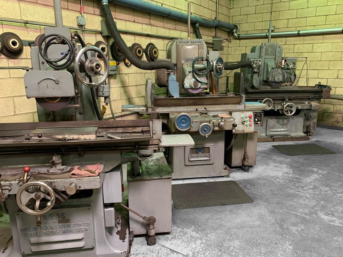 A row of grinding machines are lined up in a room.