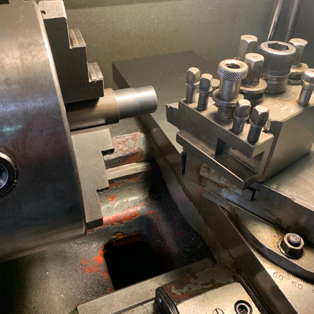 A lathe with a bunch of nuts and bolts on it