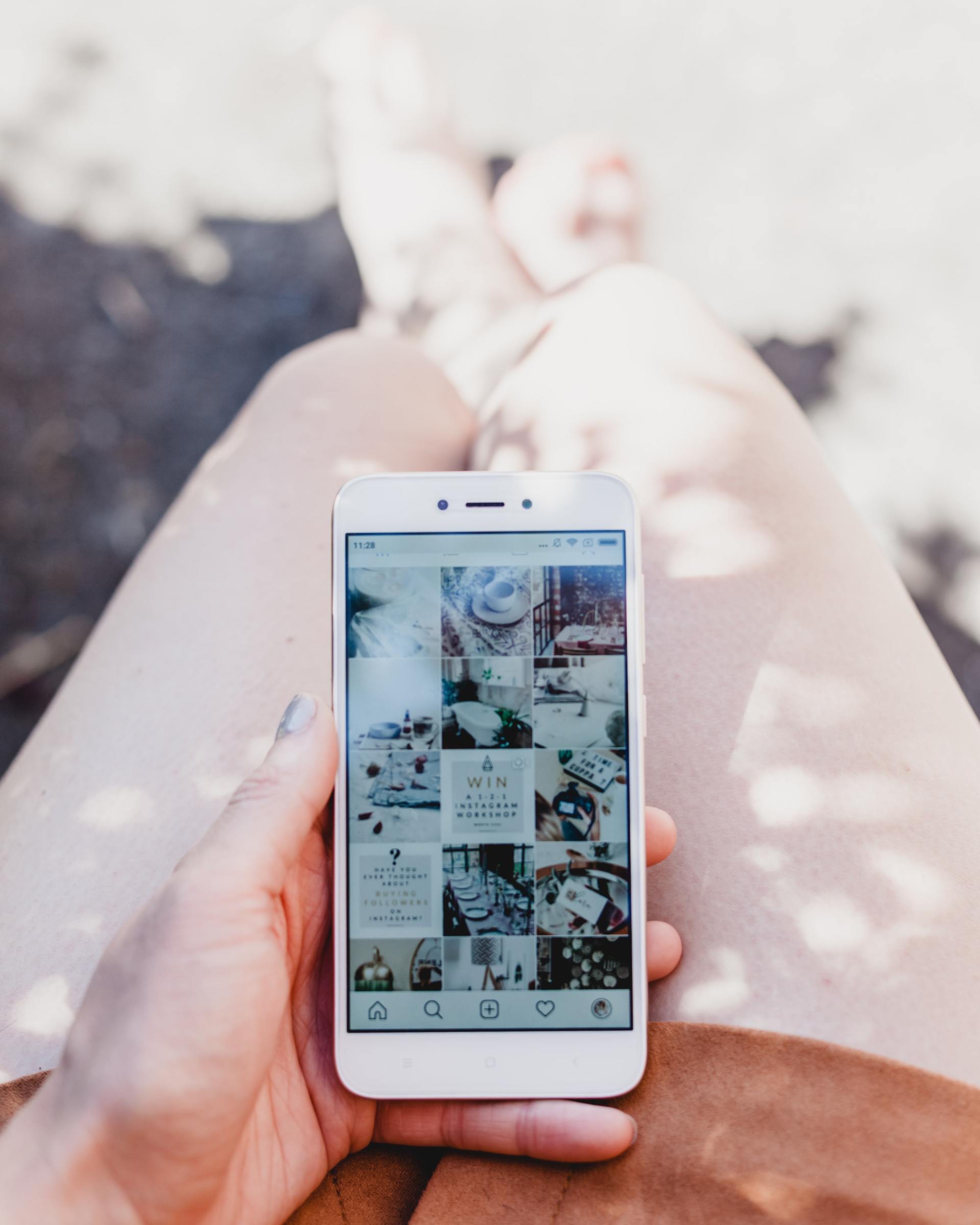 A woman holding a phone on top of her legs