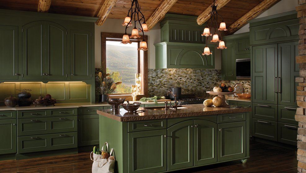 A kitchen with green cabinets and a large island.