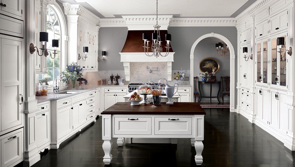 A kitchen with white cabinets and a large island in the middle.