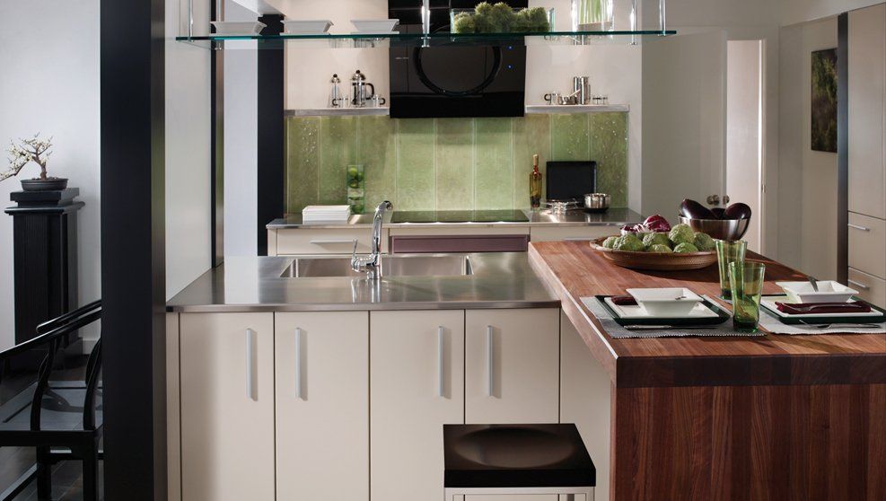 A kitchen with white cabinets and a wooden counter top