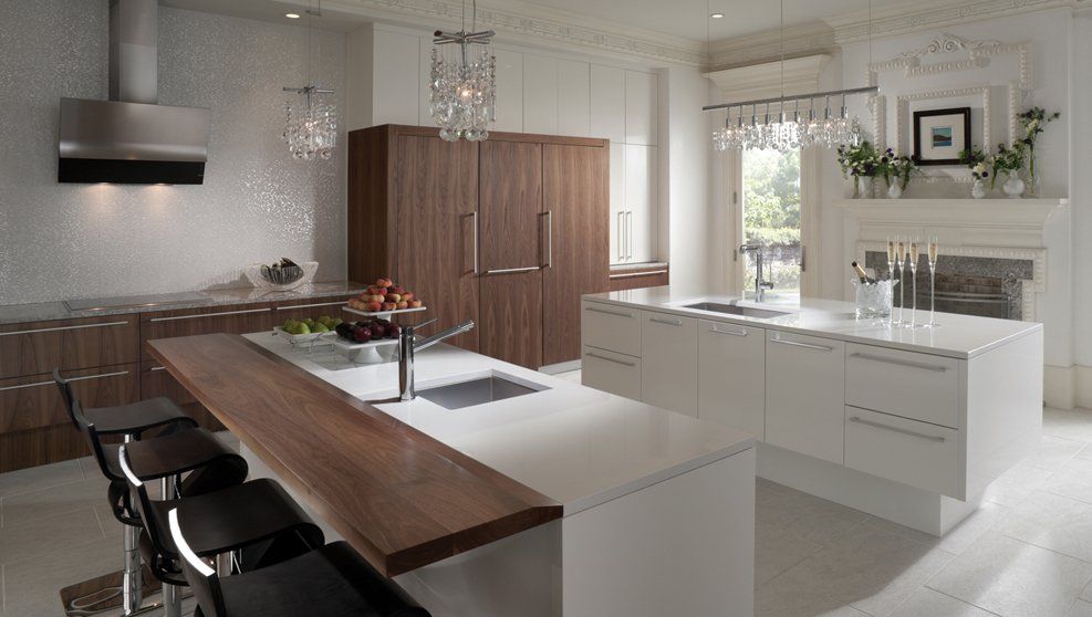 A kitchen with white cabinets and a large island with a wooden counter top.