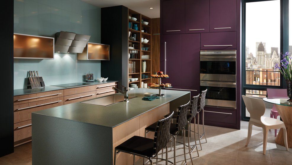 A kitchen with purple cabinets and stainless steel appliances