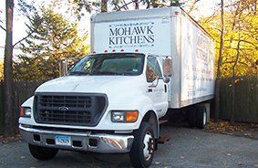 A white mohawk kitchens truck is parked in a driveway