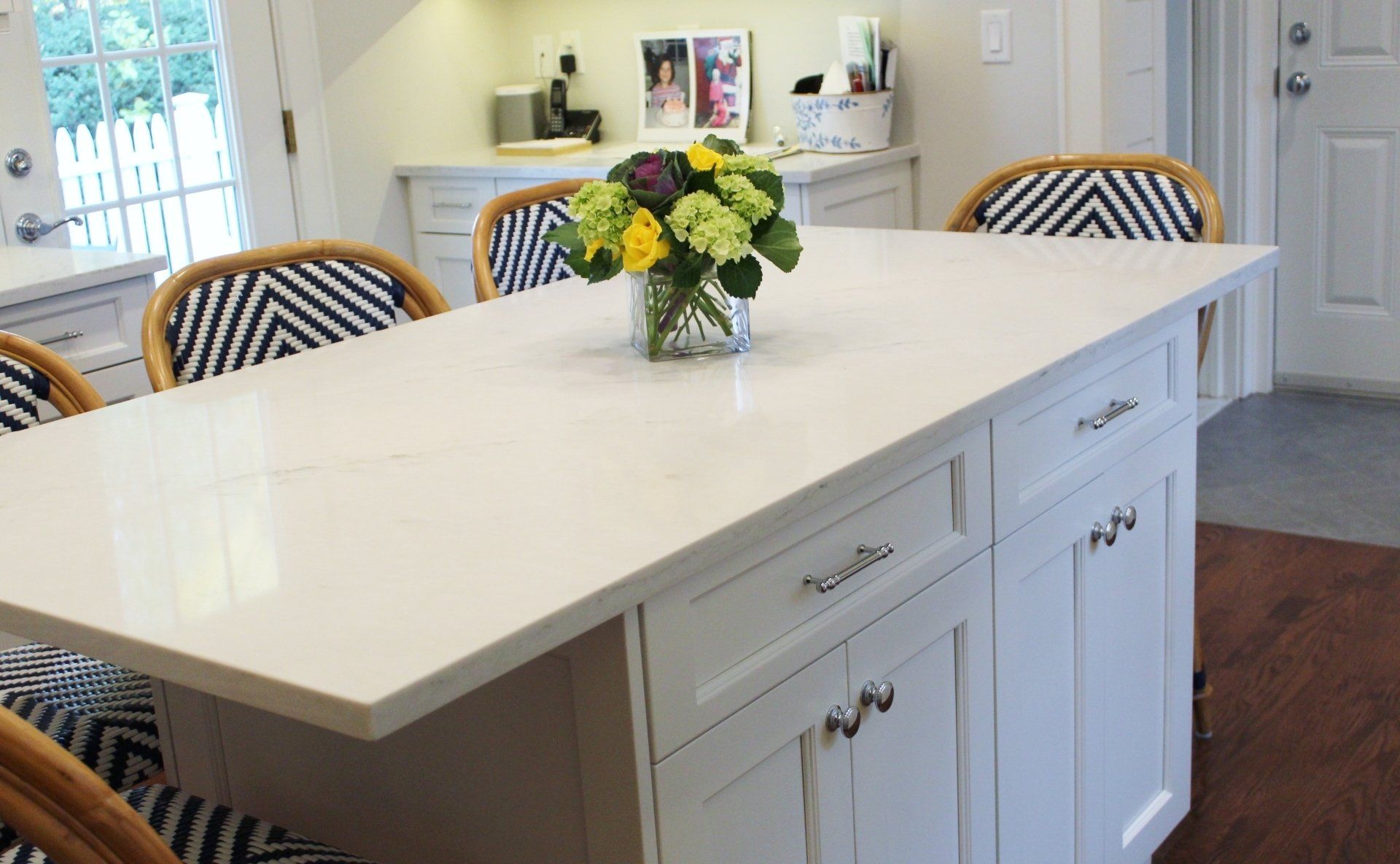 A kitchen island with a vase of flowers on it