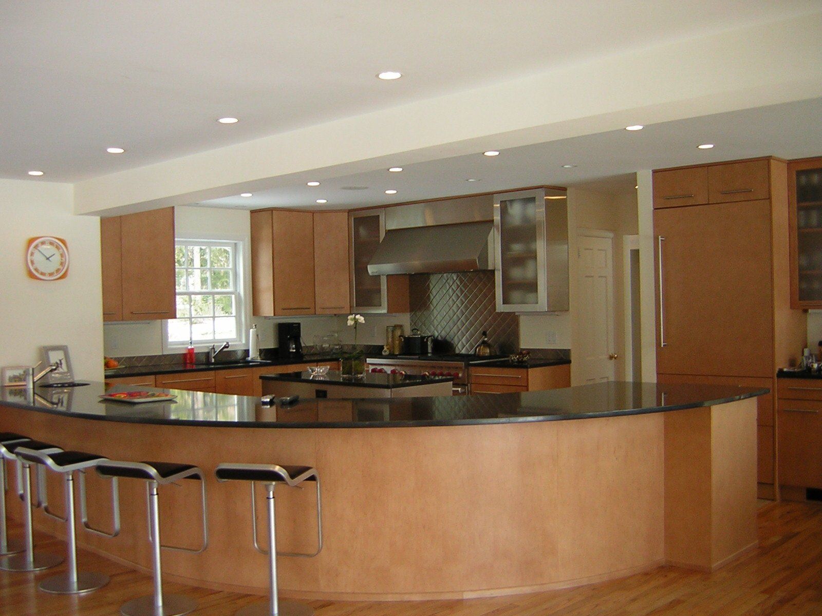 A kitchen with stools and a clock on the wall
