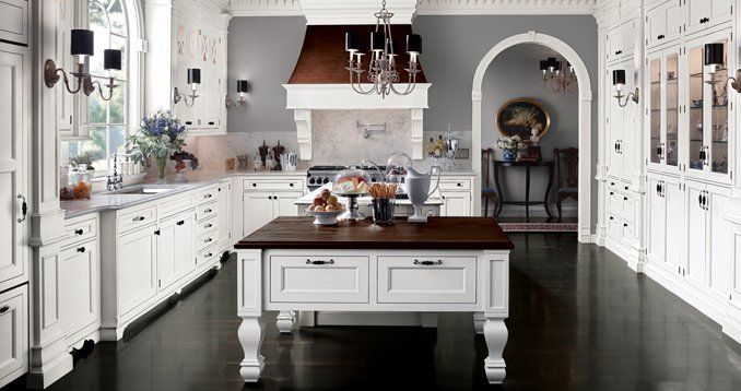 A kitchen with white cabinets and a large island in the middle.