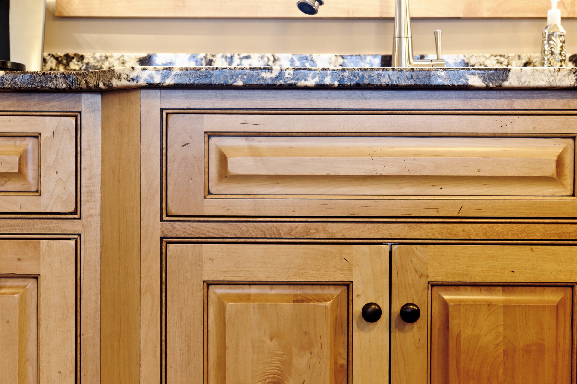 Wooden kitchen cabinets and granite countertop with a sink and faucet