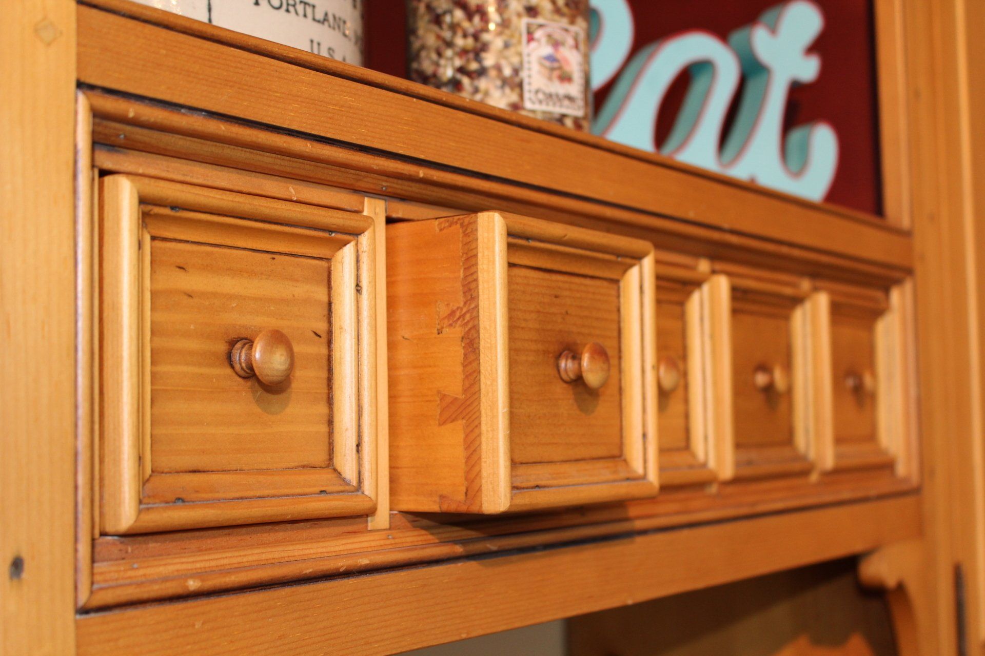 Wooden drawer cabinet with small square knobs in a warm indoor setting