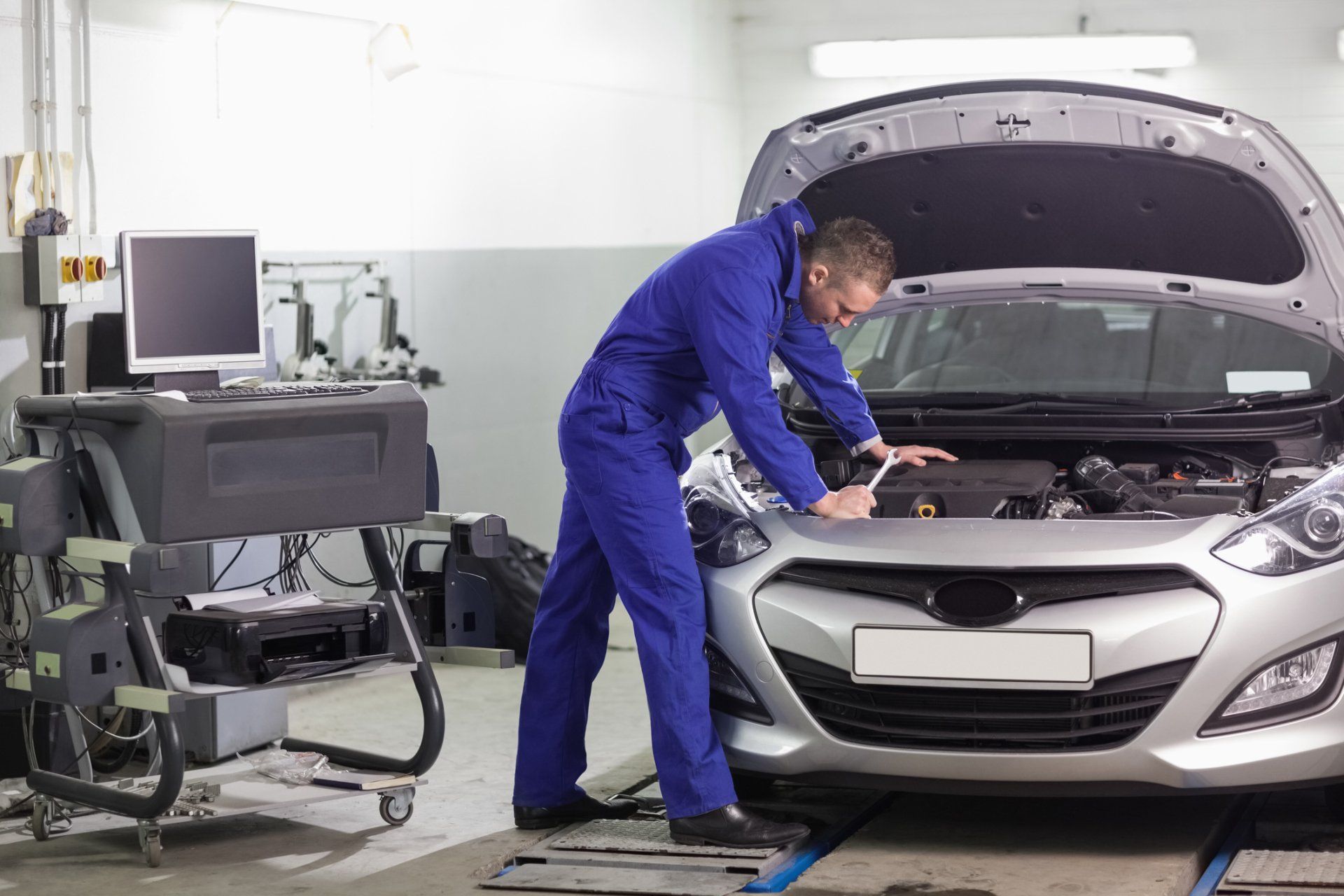 Mechanic Leaning on a Car Looking at The Engine - Transmission Repair in Mansfield, OH Mechanic Leaning on a Car Looking at The Engine - Transmission Repair in Mansfield, OH