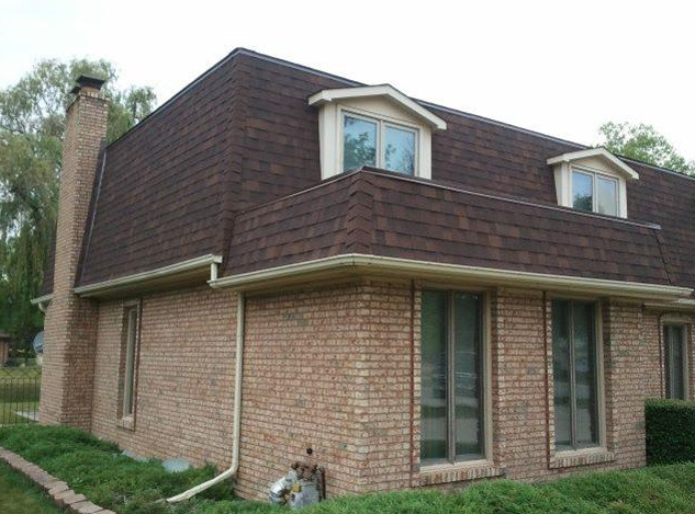 A brick house with a brown roof and a chimney