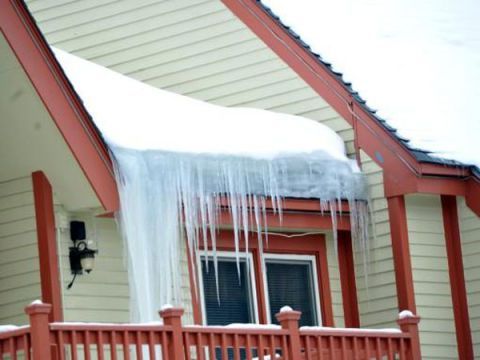 Icicles are hanging from the roof of a house