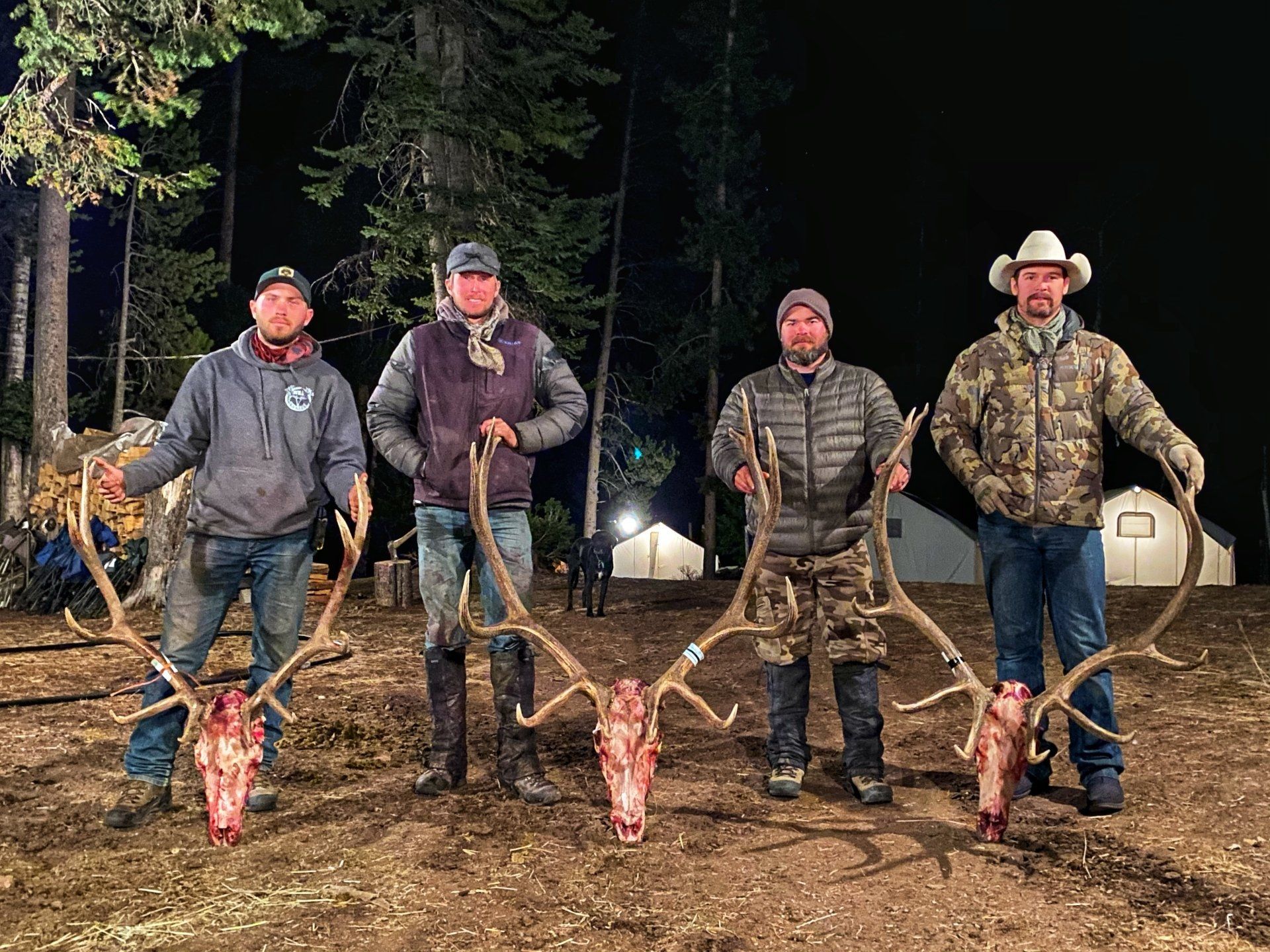 A group of men standing next to each other holding deer antlers.