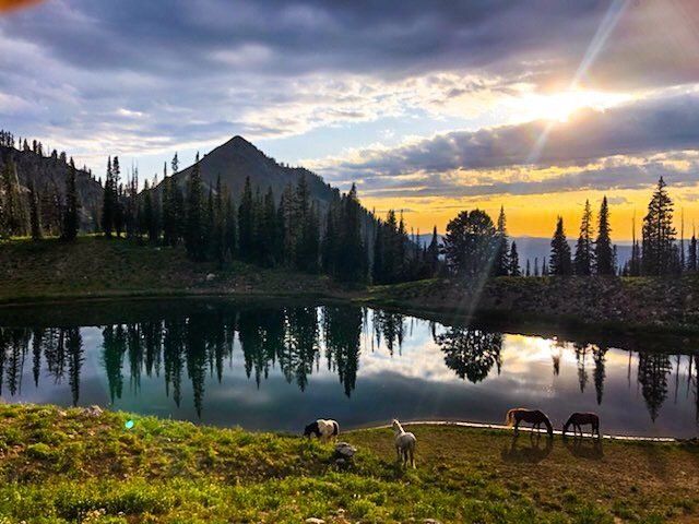 A sunset over a lake with a mountain in the background