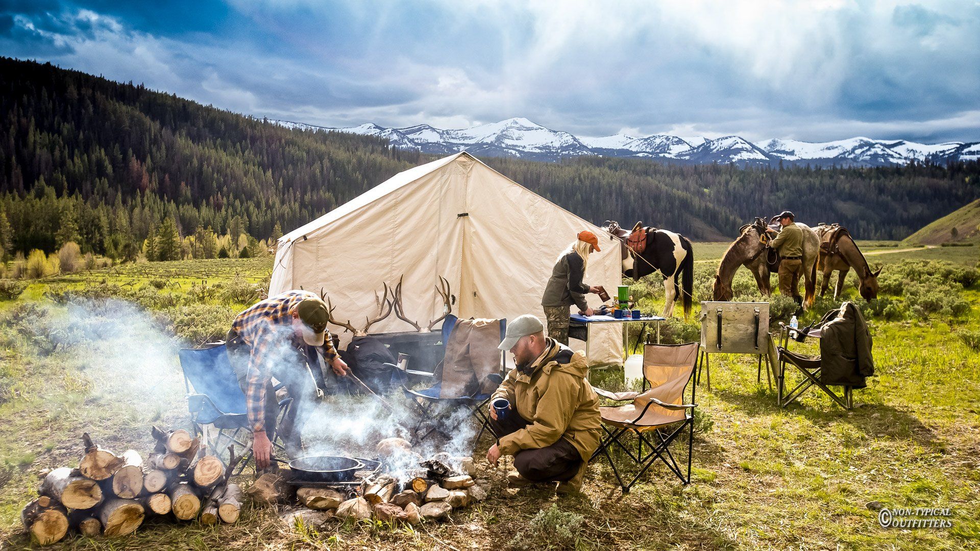 A group of people sitting around a campfire in a field