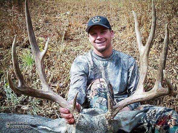 A man is holding a large deer in his hands.