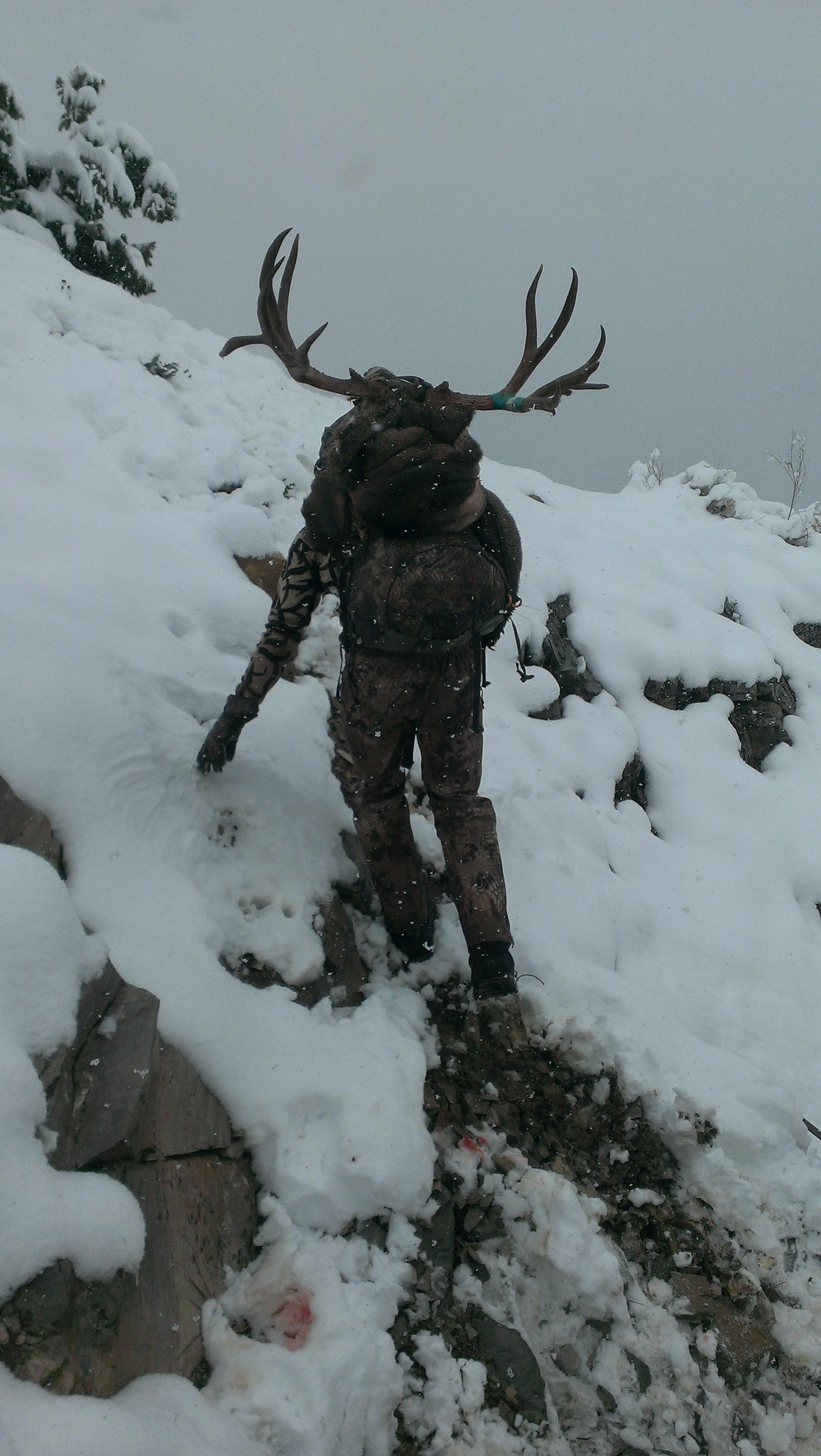 A person with antlers is walking in the snow