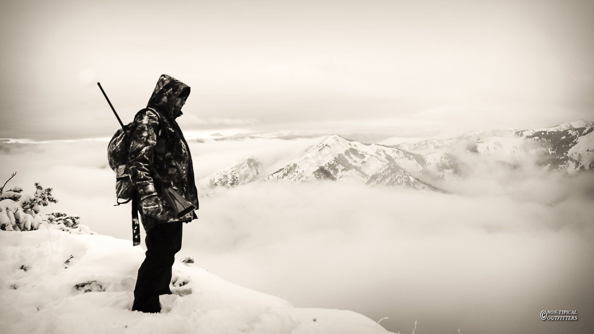 A person standing on top of a snow covered mountain