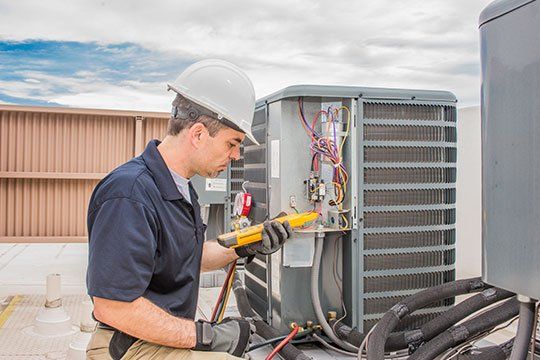 Worker Holding A Voltage Meter — Victoria, TX — AAA Air Conditioning, Inc. Worker Holding A Voltage Meter — Victoria, TX — AAA Air Conditioning, Inc.