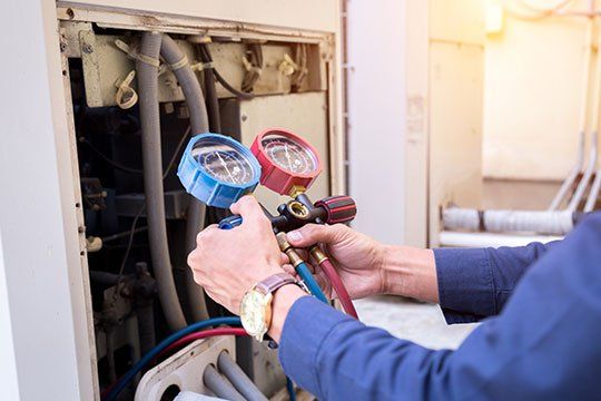 Worker Checking Air Conditioner — Victoria, TX — AAA Air Conditioning, Inc. Worker Checking Air Conditioner — Victoria, TX — AAA Air Conditioning, Inc.