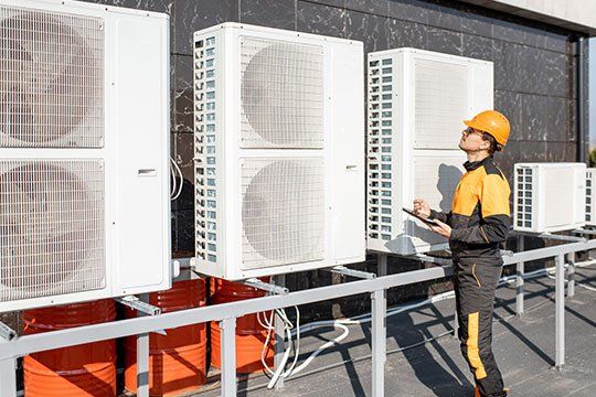 Worker Checking Big Air Conditioner — Victoria, TX — AAA Air Conditioning, Inc. Worker Checking Big Air Conditioner — Victoria, TX — AAA Air Conditioning, Inc.