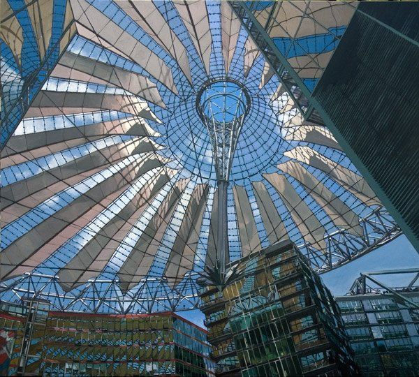 Een constructie met glazen panelen vormt vanuit het midden een brede, waaiervormige overkapping boven een stadsplein uit.