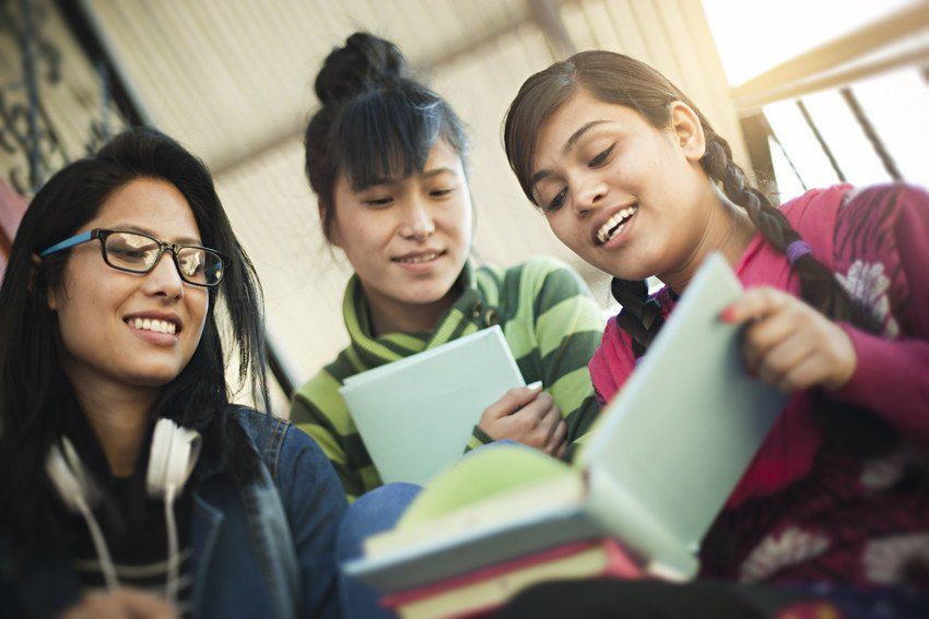 young women looking at coursework