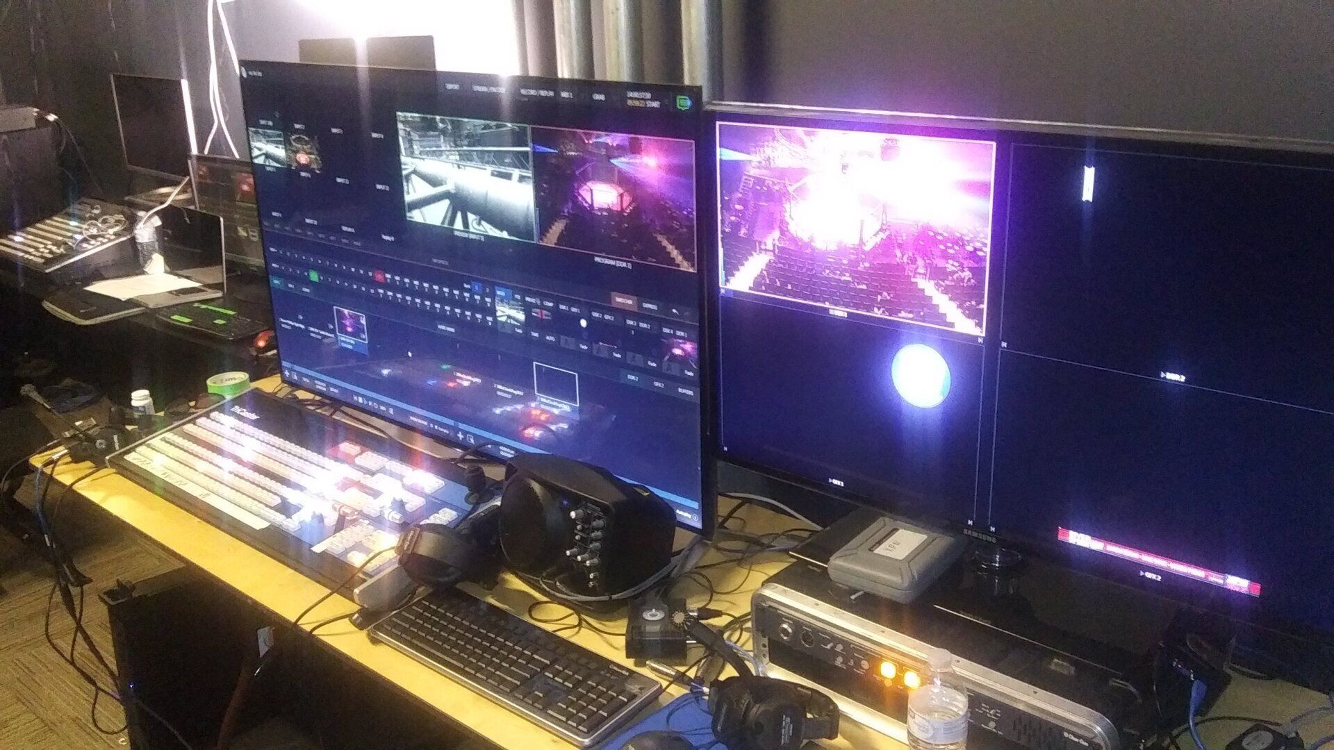 A computer desk with three monitors and a keyboard