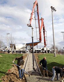 heavy equipment pumping concrete onto a construction site