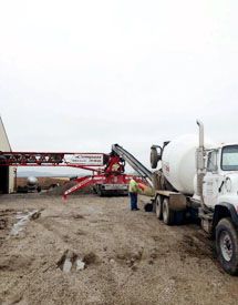 heavy equipment pumping concrete onto a construction site