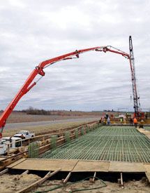 heavy equipment pumping concrete onto a construction site