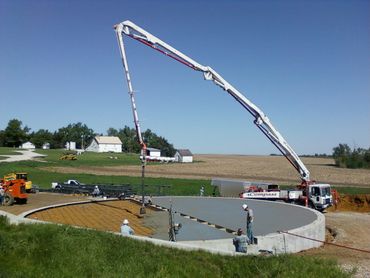worker pouring concrete into a work site
