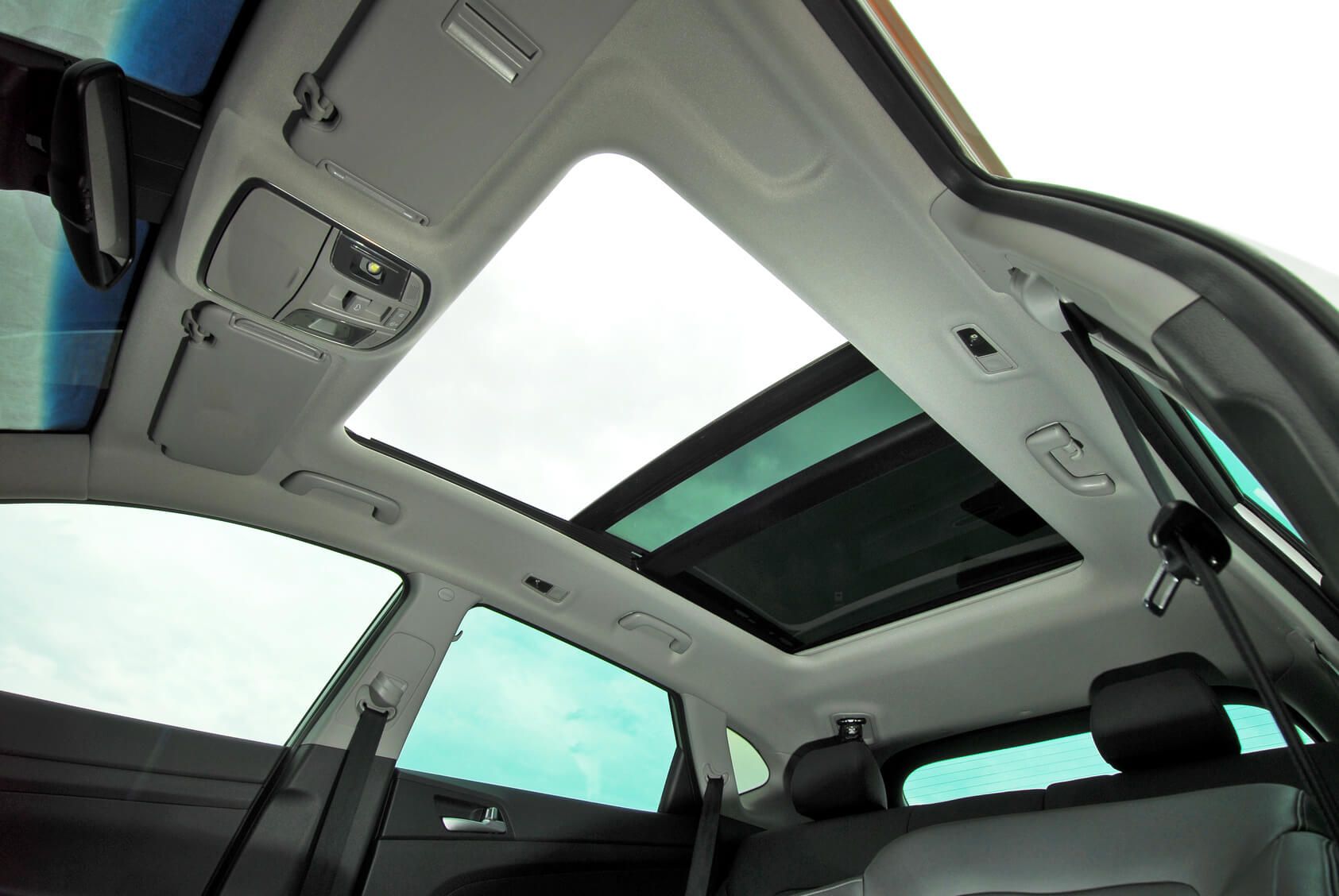 glass sun roof open from the interior of car after sunroof replacement and repair services
