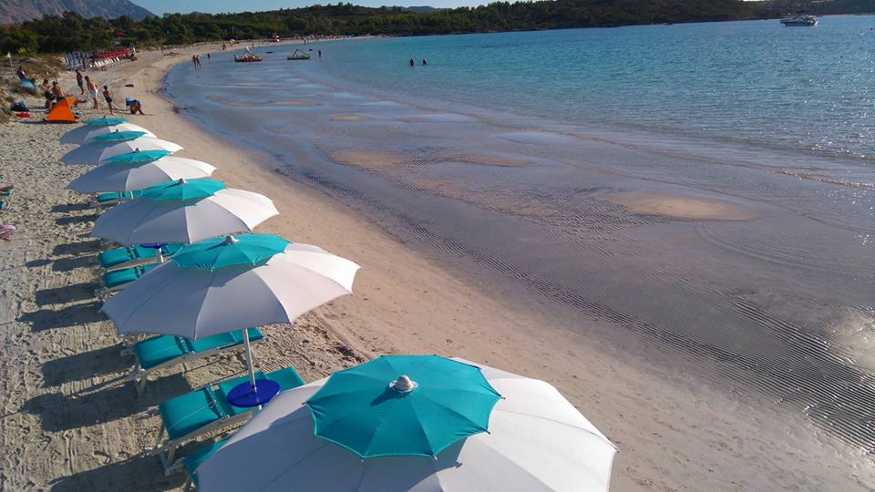 spiaggia con ombrelloni aperti azzurri e bianchi