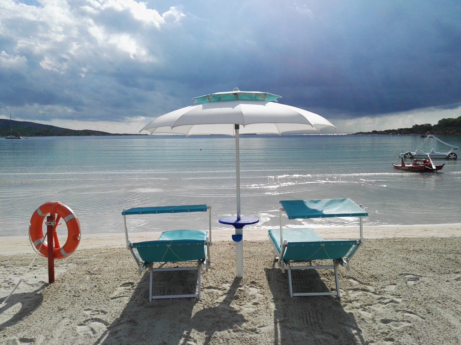 ombrellone con due sdraio in spiaggia