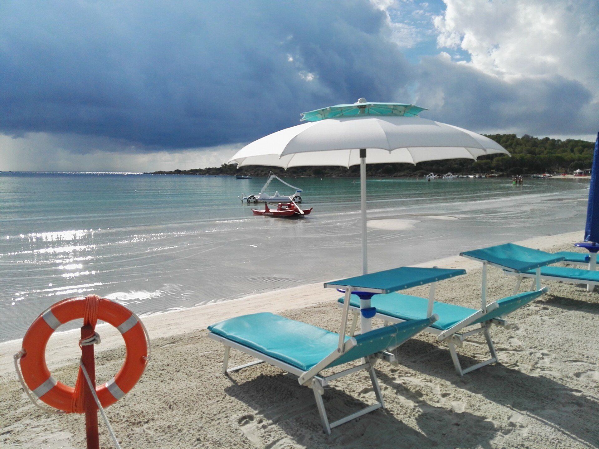spiaggia con ombrellone, sdraio, canoa e pedalò