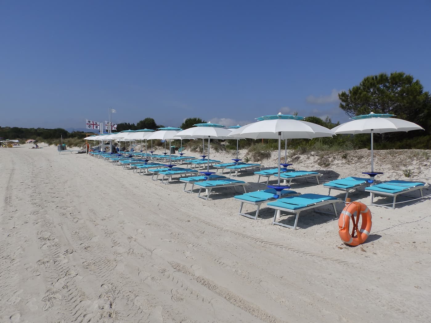 spiaggia con sabbia chiara e lettini azzurri