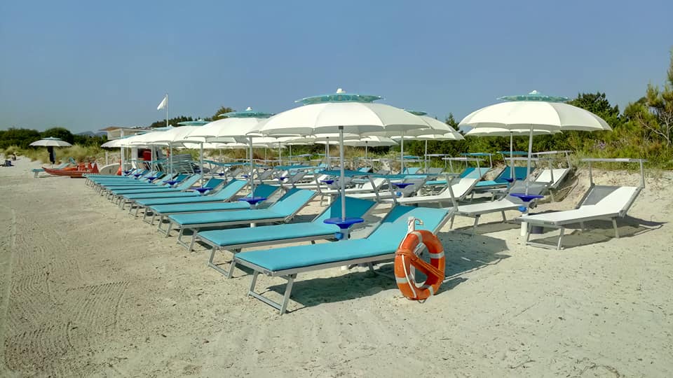 ombrelloni bianchi e lettini azzurri da spiaggia